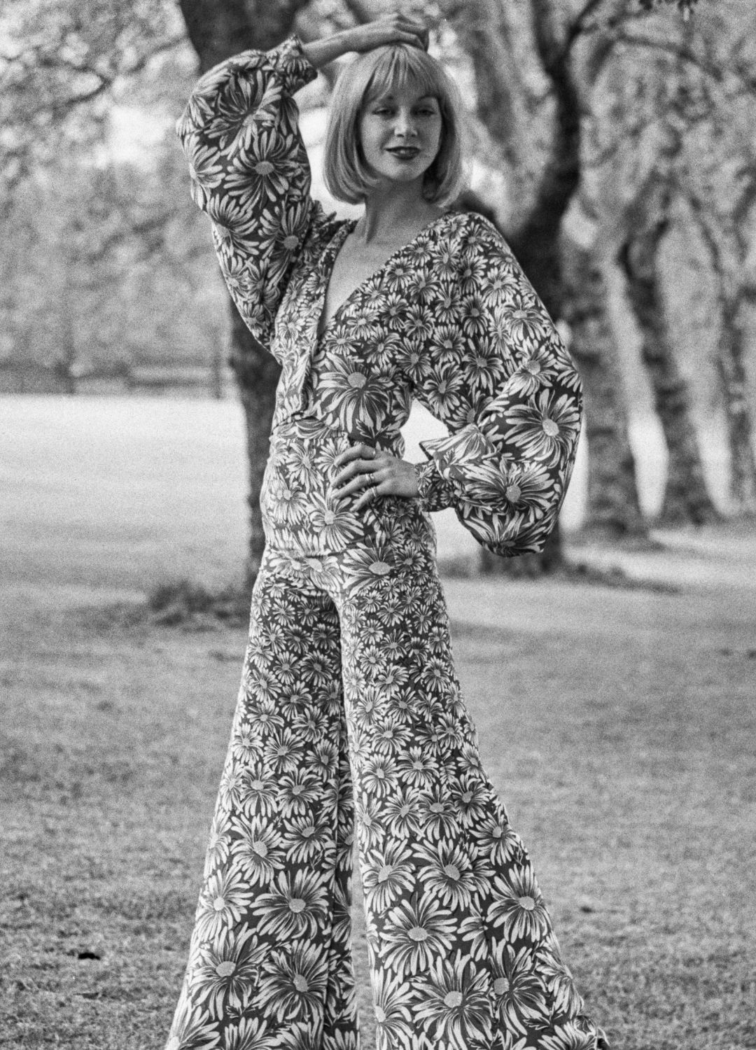 A model wearing a flared trouser suit in a floral fabric, UK, 1st May 1972.