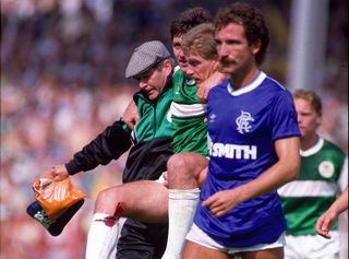 Rangers' Graeme Souness leaves the pitch after being sent off for a challenge on Hibs' George McCluskey, who is carried off for treatment, in August 1986.