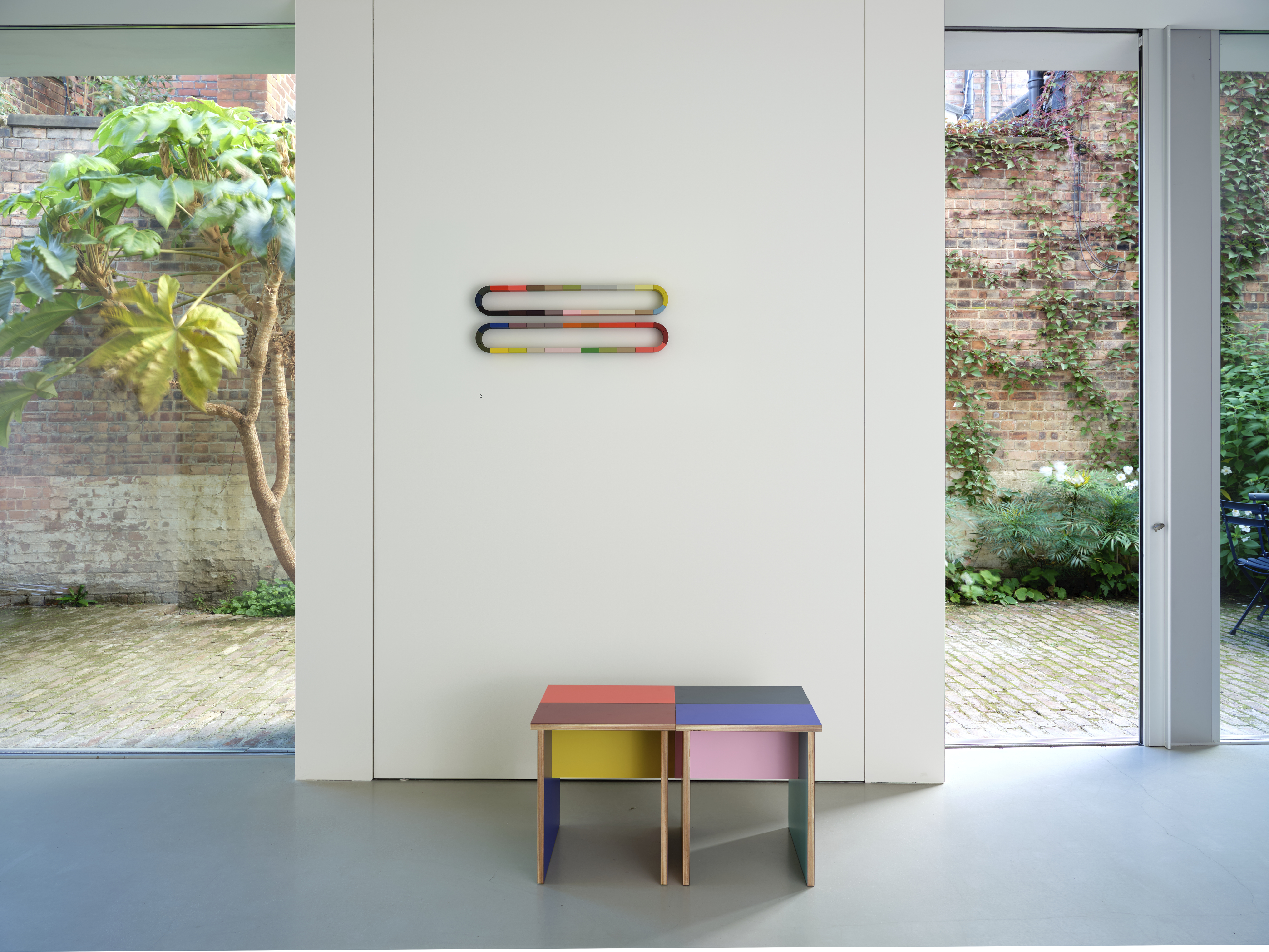 Tables made of colourful plywood sections intersected, made by Sophie Smallhorn for Uncommon projects