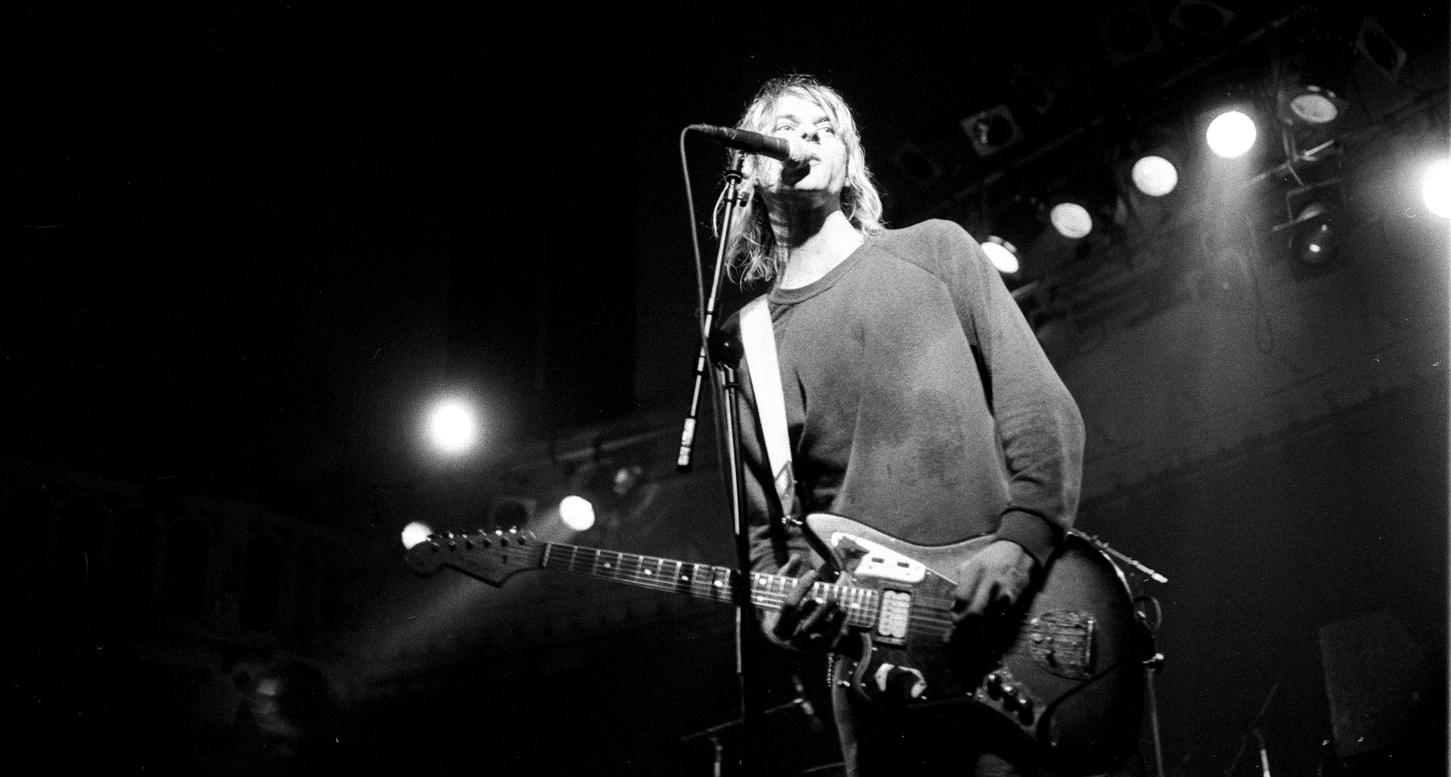 A black-and-white live shot of Kurt Cobain performing in 1991 with Nirvana