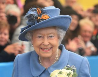 Queen Elizabeth II on a royal visit wearing blue 