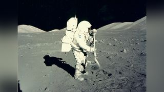 Apollo 17 astronaut Jack Schmitt uses a rake on the surface of the moon.
