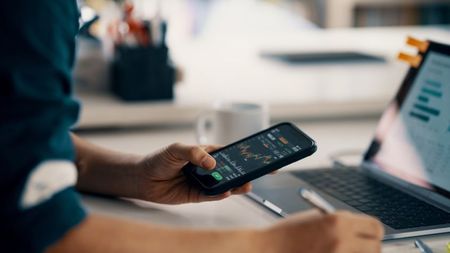 man checking financial information on a smart phone