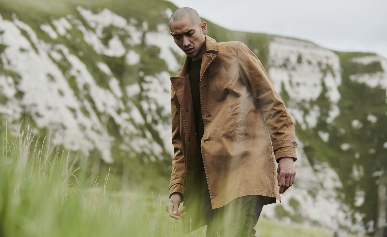 Model wears coat in natural setting