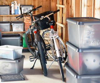 plastic stacking tubs in garage with wooden shelving and bikes