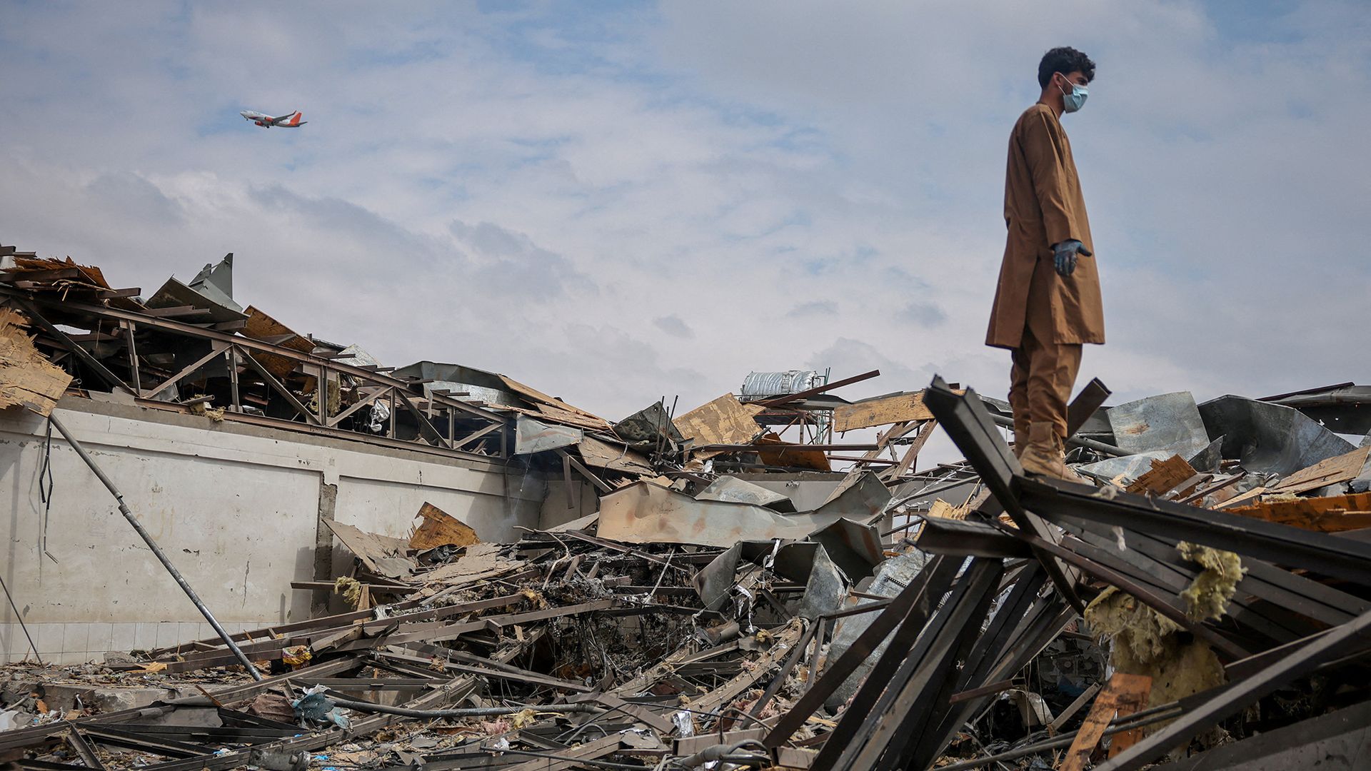 
                                A man stands atop debris that Afghan officials allege was a medical center destroyed by a Pakistani air strike, in Kabul, Afghanistan
                            