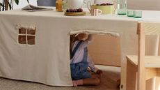 Ferm Living tablecloth tent with windows and roll-up door and kid underneath the table