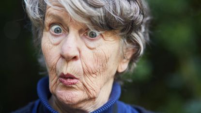 A retired woman has a surprised look on her face.