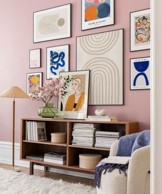 An entryway with a colorful gallery wall, a brown console table, and a white rug