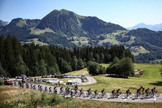 The pack of riders cycles in the ascent of Col de la Croix Fry in the French Alps during the 15th stage of the 110th edition of the Tour de France cycling race, 179 km between Les Gets Les Portes du Soleil and Saint-Gervais Mont-Blanc, in eastern France, on July 16, 2023. (Photo by Anne-Christine POUJOULAT / AFP)