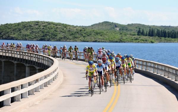 The peloton make rapid progress over the water.