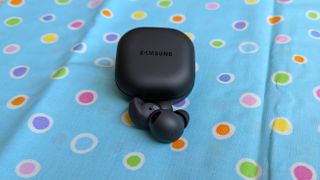 The Samsung Galaxy Buds 2 Pro being displayed atop a polka-dot-designed fabric cloth