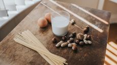 Group of commonly known allergens on a table, including eggs, milk, nuts and pasta.