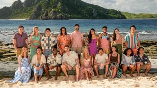 A group photo of the cast of Survivor Season 47 on a tropical beach with a mountainous backdrop