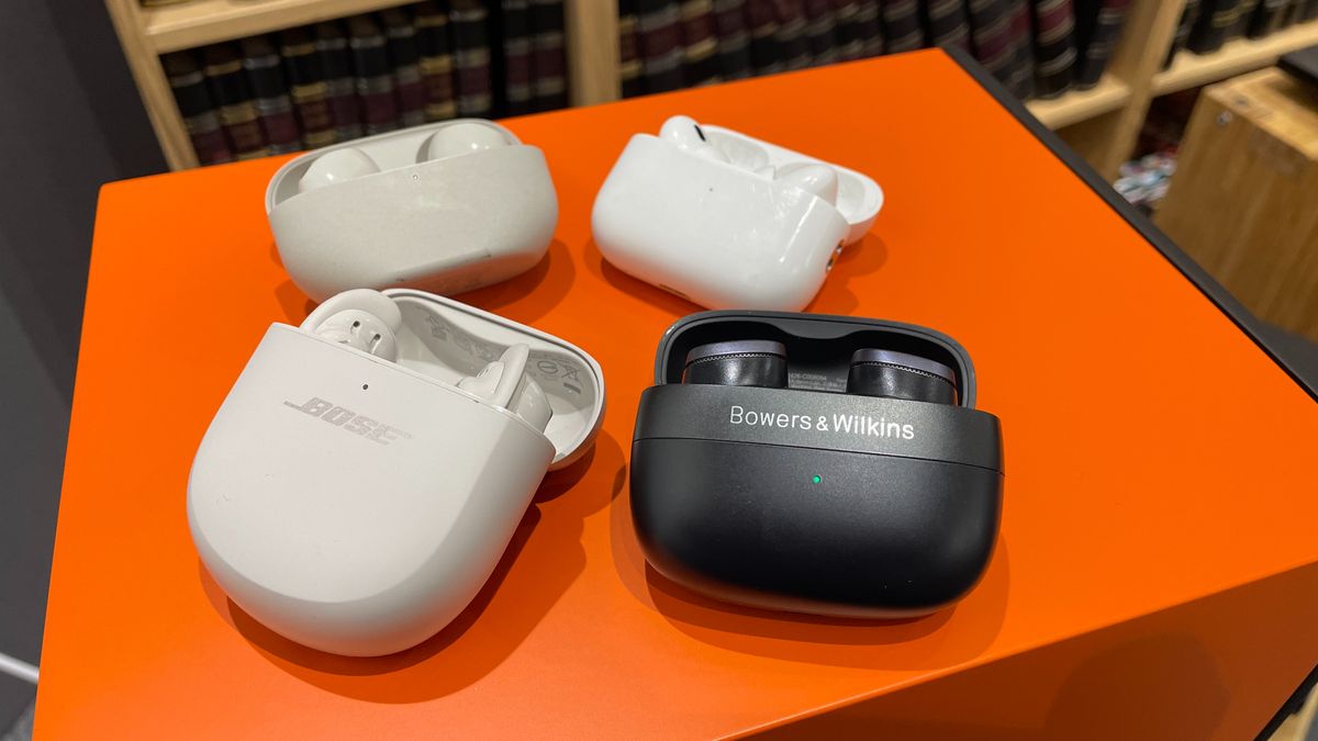 Bose QC Ultra Earbuds, Sony WF-1000XM5, Apple AirPods Pro 2 and B&amp;W Pi8 wireless earbuds sat on the top of an orange Epos speaker