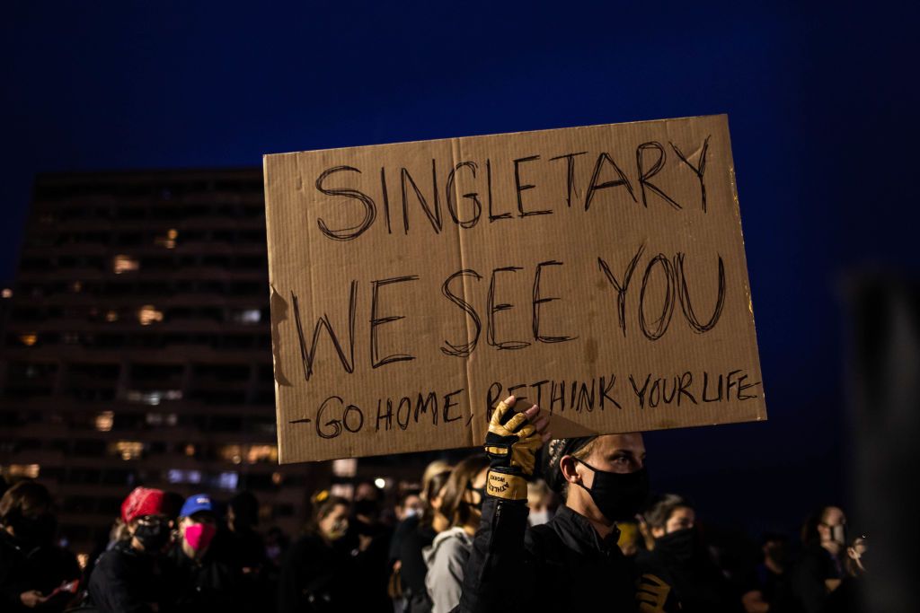 Rochester protester holds a sign condemning police chief.