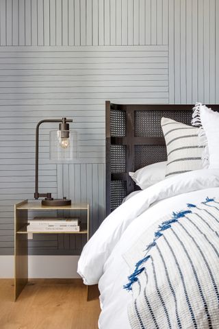 grey bedroom with accent wall, metal headboard and metal bedside table, metal table lamp