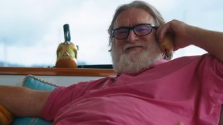 Gabe Newell in a pink shirt talking on the phone