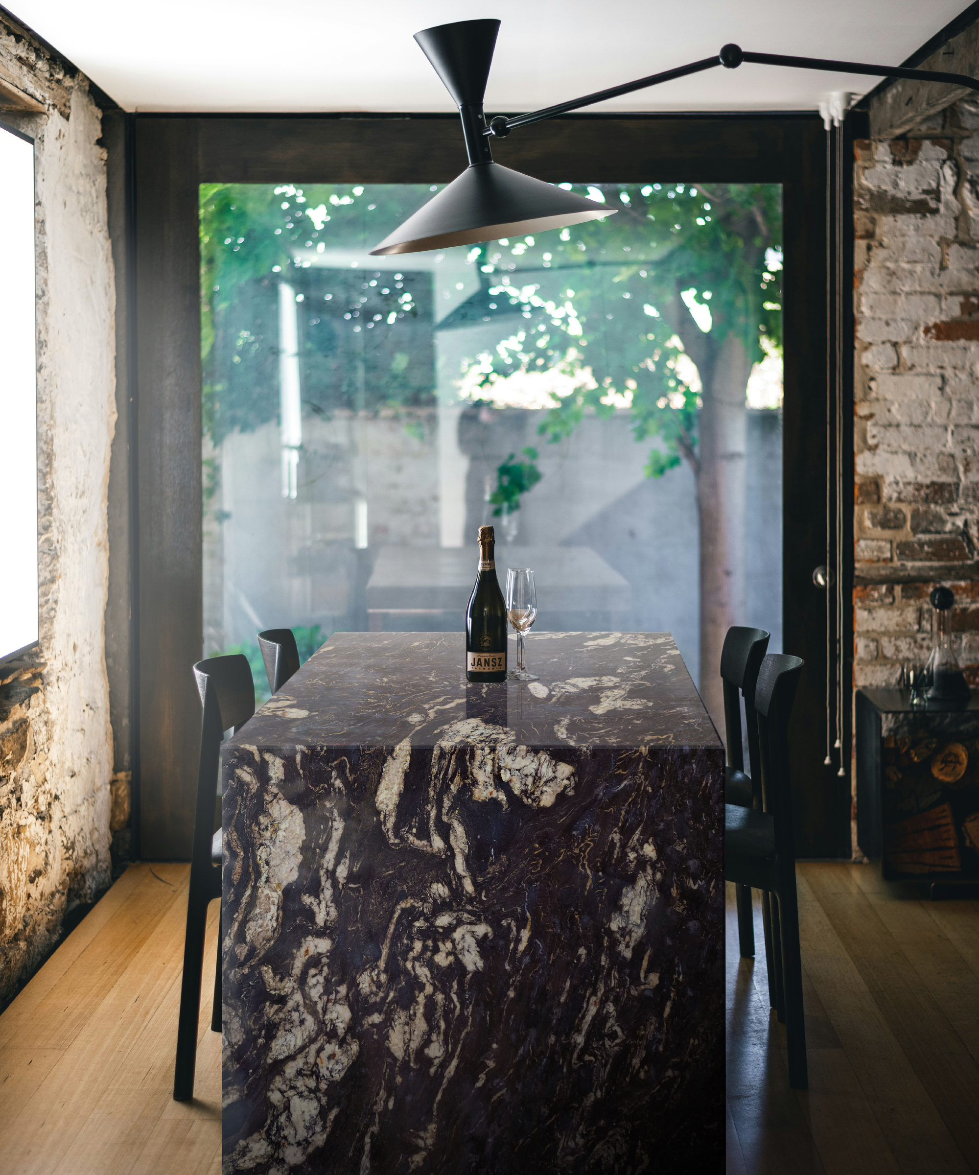 black granite kitchen island with waterfall worktop, black chairs and large black pendant light