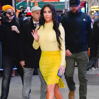 Kim Kardashian waves at the camera