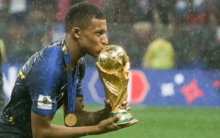 Kylian Mbappe kissing the World Cup