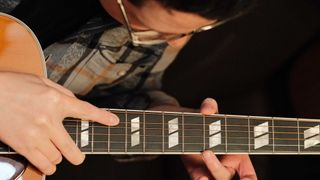 Customer checking the frets of an acoustic guitar