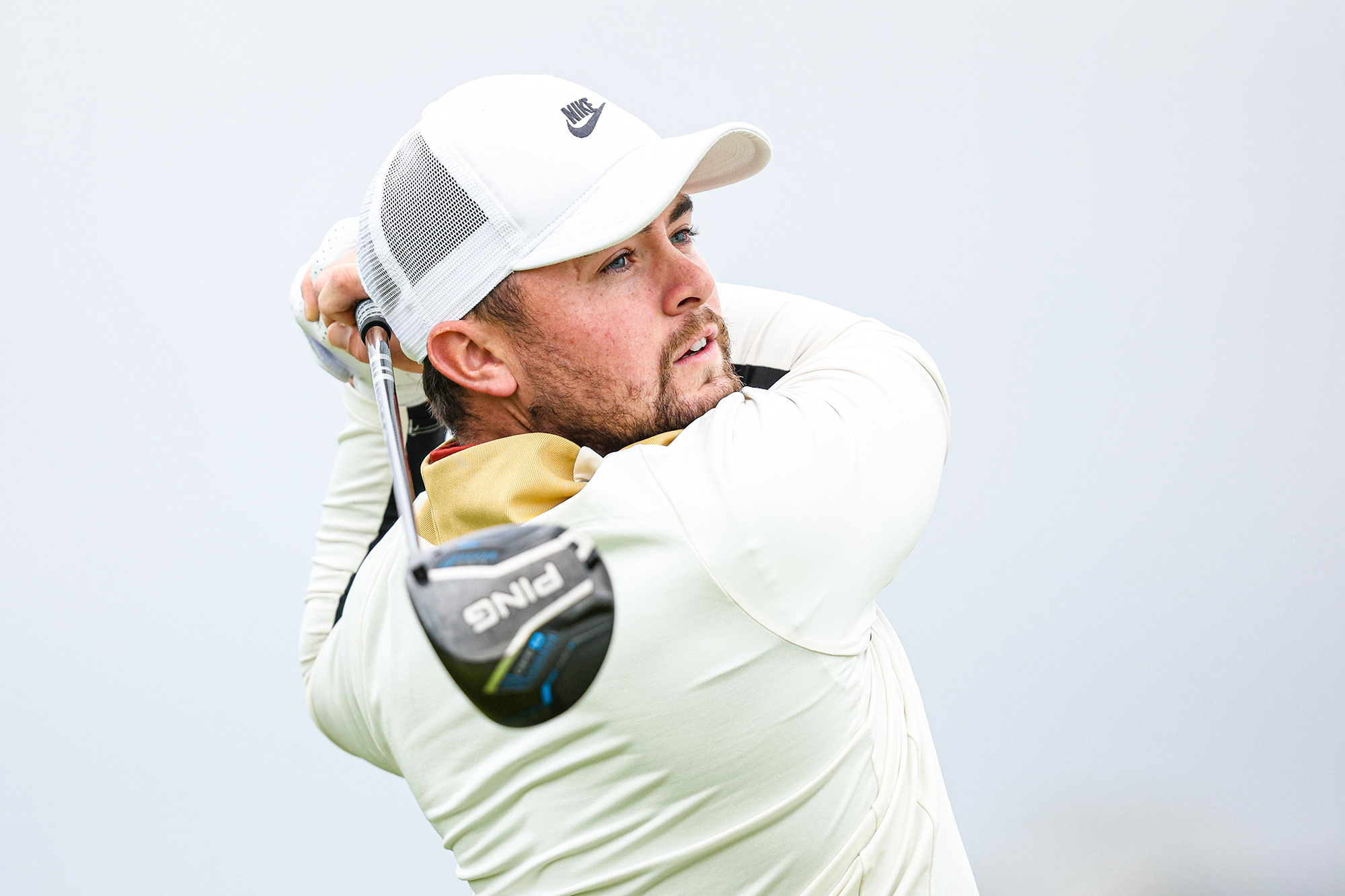 Alex Fitzpatrick in the finish position with driver, watching the ball in flight after taking his tee shot