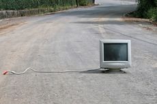 unplugged desktop computer sitting out in the middle of a road