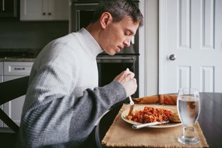 Male cyclist eating a bowl of pasta