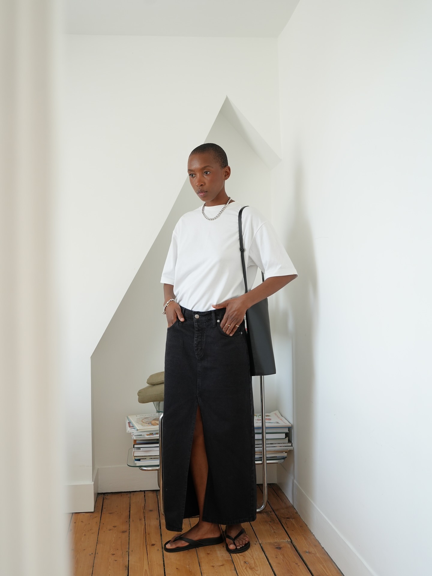 @_marisamartins_ wearing a white T-shirt with a long black denim skirt and flip-flops.