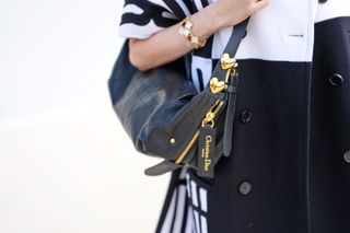 a close up of the dior d journey bag on a guest at Paris Fashion Week