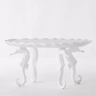 white coffee table with seahorse statues as legs