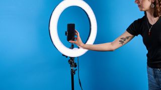 Neewer RL-18 ring light photographed in front of a blue background. 