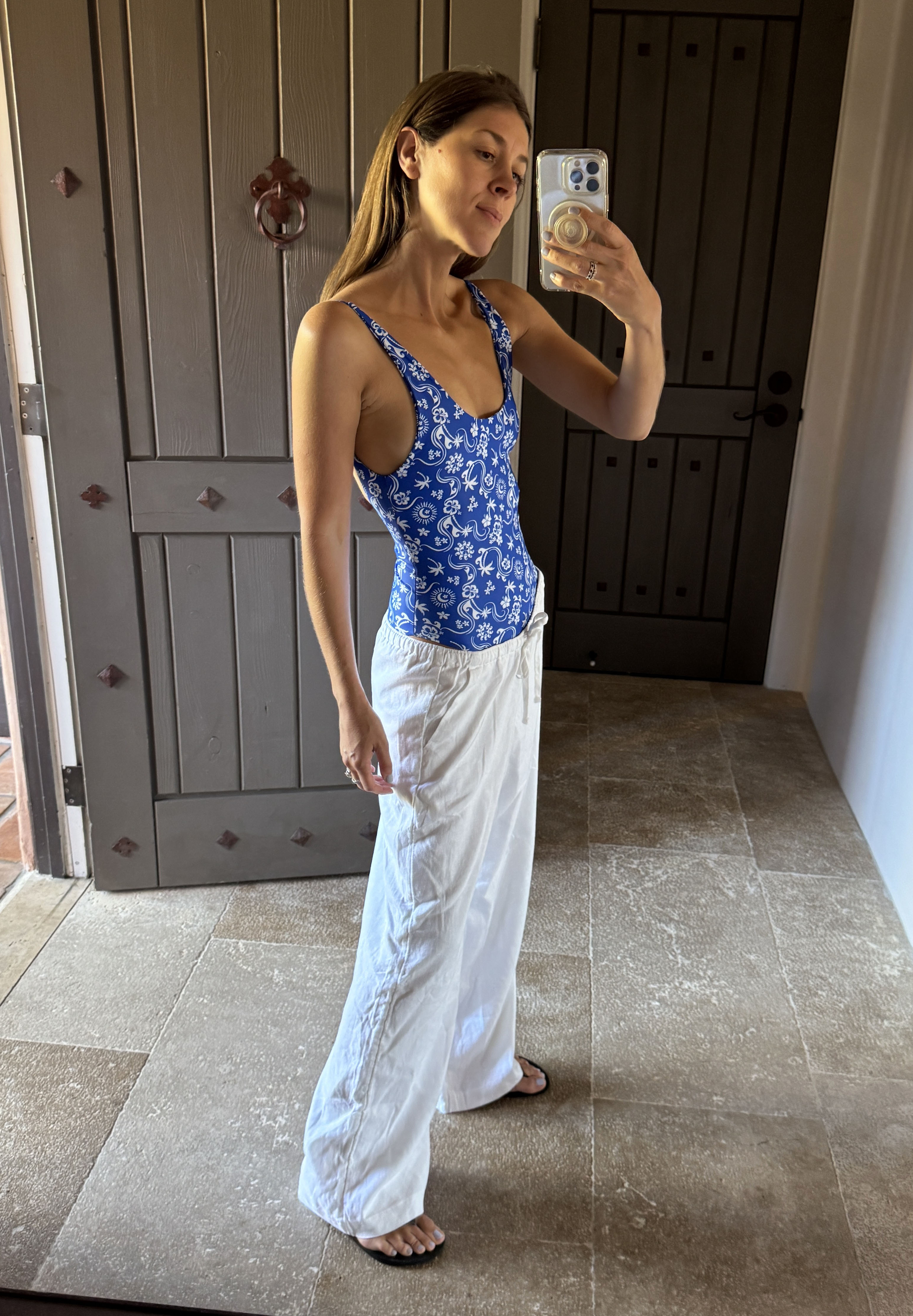 Woman in blue swimsuit and white Hollister low-rise pants