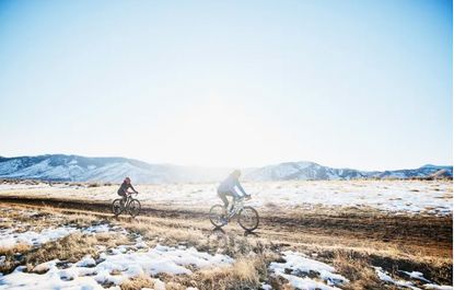 Two cyclists riding in snow