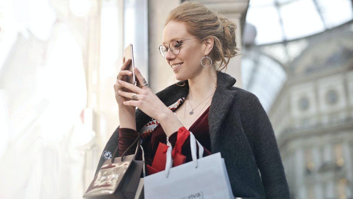 best iPhone keyboard: Woman standing in street with shopping bags using phone