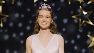 Summer H. Howell's Carrie White smiling while wearing a white dress and tiara in Mike Flanagan's Carrie TV show