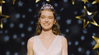Summer H. Howell's Carrie White smiling while wearing a white dress and tiara in Mike Flanagan's Carrie TV show
