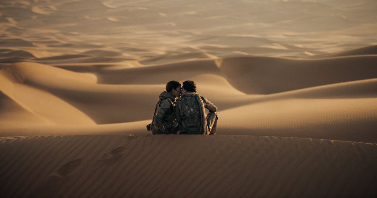 two men in the dessert sitting close to each other