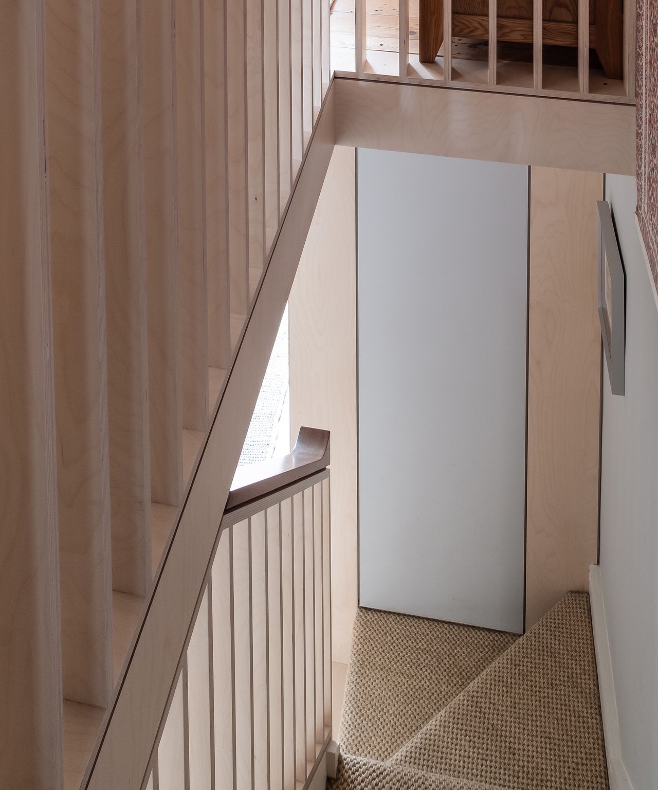 A narrow staircase in a Victorian terrace with plywood details