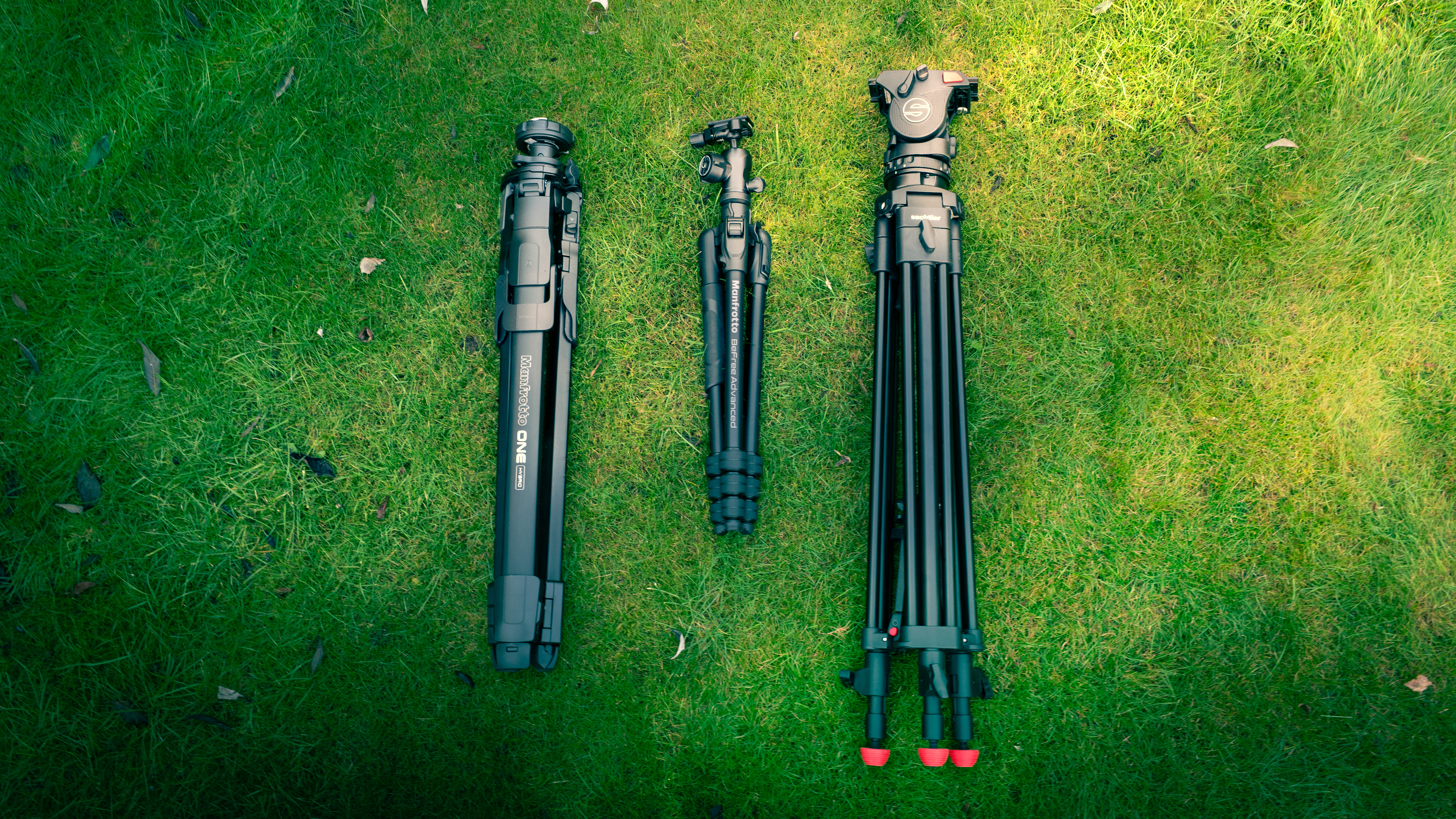 Sachtler and Manfrotto tripods on a grassy background