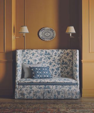ochre wall with french decor sofa in toile blue and white fabric