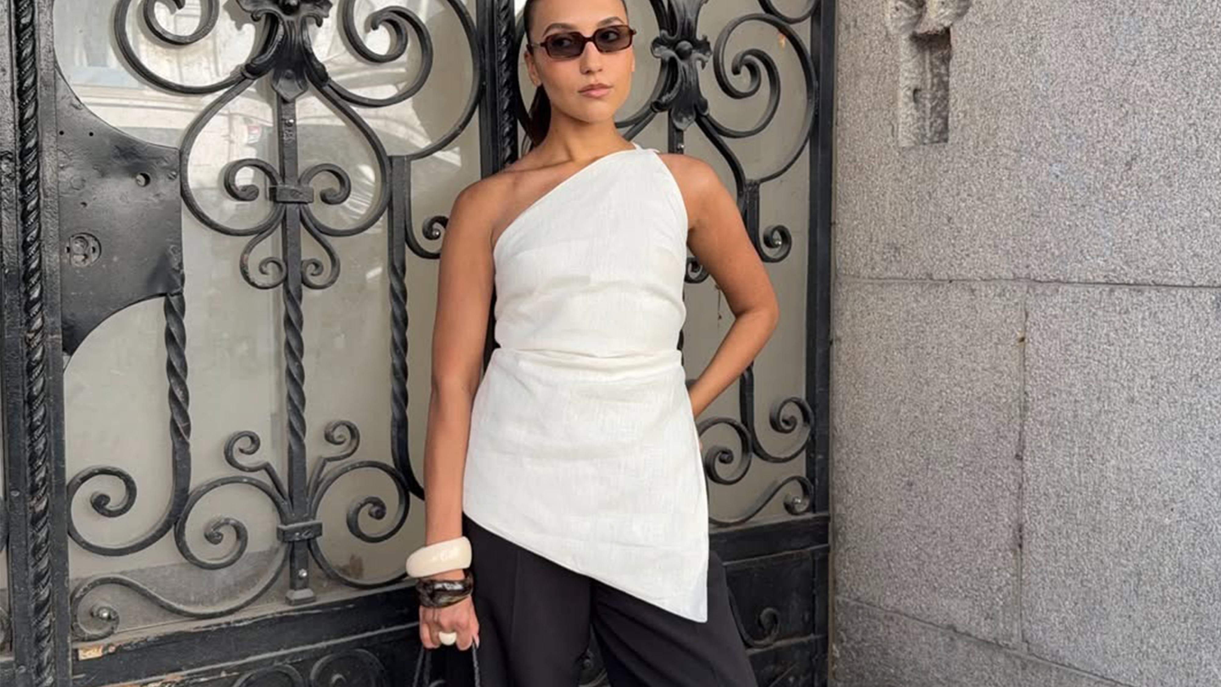 Woman in a chic top and black pants.