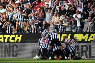 Fans of Newcastle United celebrate as Kieran Trippier of Newcastle United celebrates with teammates after scoring their side's third goal from a free kick during the Premier League match between Newcastle United and Manchester City at St. James Park on August 21, 2022 in Newcastle upon Tyne, England.