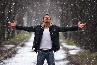 A man looks happy on a snowy day.