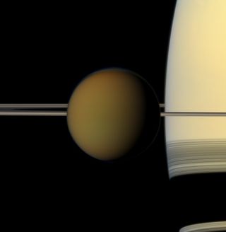 Saturn's largest moon, Titan, passes in front of the planet and its rings in this true color snapshot from NASA's Cassini spacecraft. This view looks toward the northern, sunlit side of the rings from just above the ring plane. It was taken on May 21, 2011, when Cassini was about 1.4 million miles (2.3 million kilometers) from Titan.