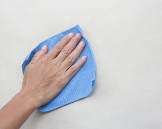 Wiping wall with blue cloth
