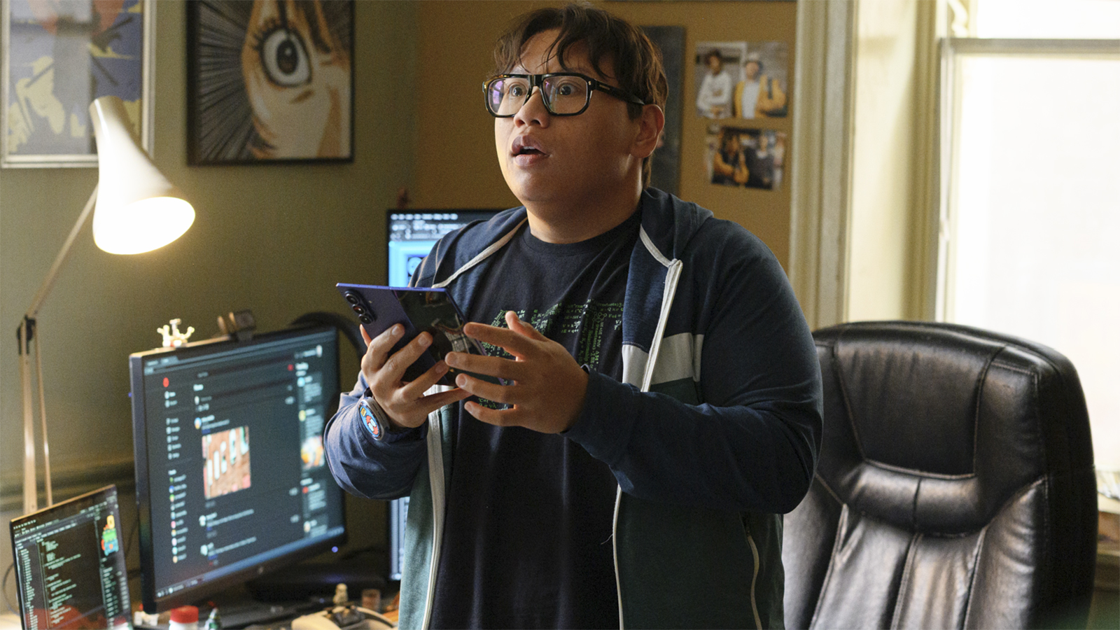 Ned Leeds with an open mouthed expression as he holds a Samsung Galaxy foldable phone in Spider-Man: Brand New Day