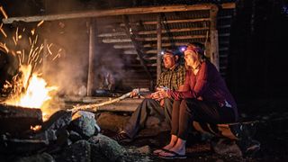 campfire safety: couple wearing headlamps with campfire