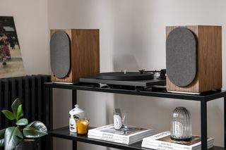 Triangle speakers shown on a record player stand